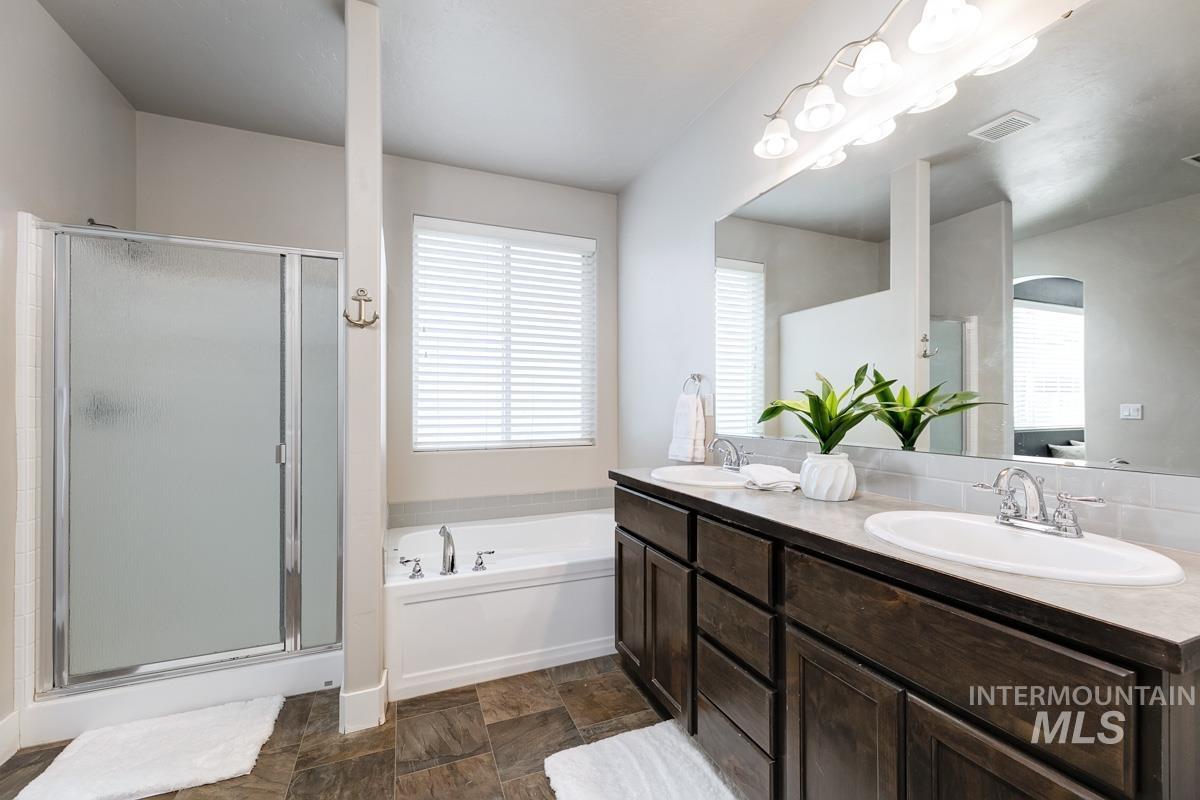 3902 North Rotaldo Avenue Meridian, ID 83646 - Photo 18 of 34 Full bathroom featuring double vanity, a bath, and a shower stall