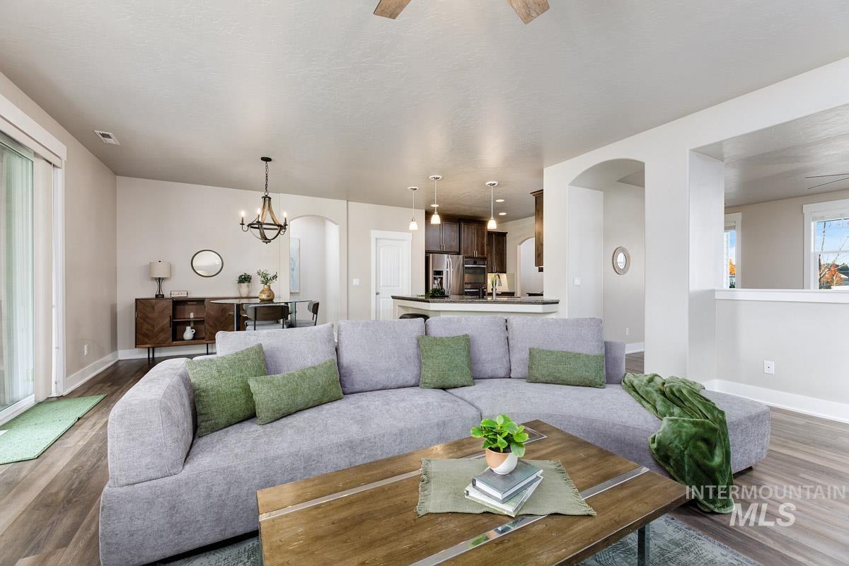 3902 North Rotaldo Avenue Meridian, ID 83646 - Photo 9 of 34 Living area with arched walkways, wood finished floors, a chandelier, and ceiling fan