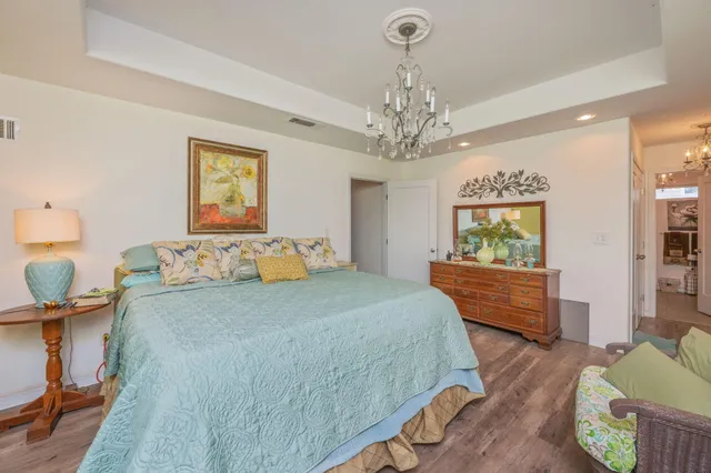 a spacious bedroom with a bed and a chandelier