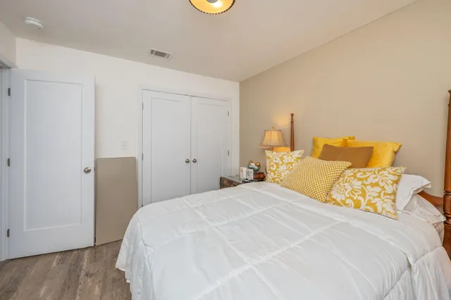 a bedroom with a bed and wooden floor