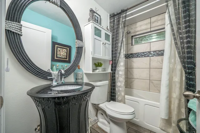 a bathroom with a toilet a sink and a mirror