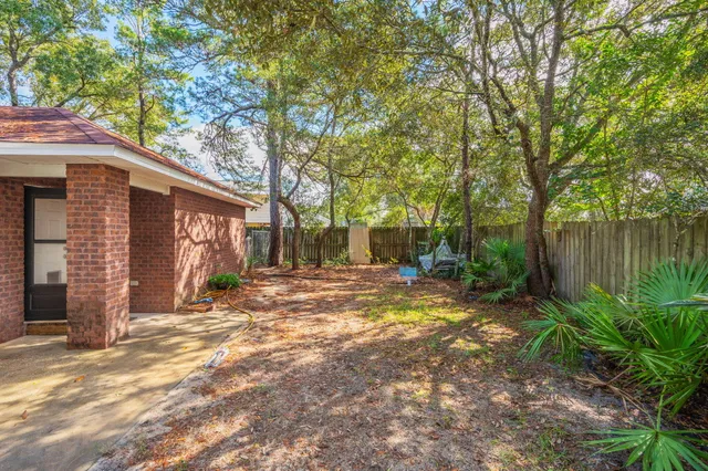 a view of a house with backyard and tree