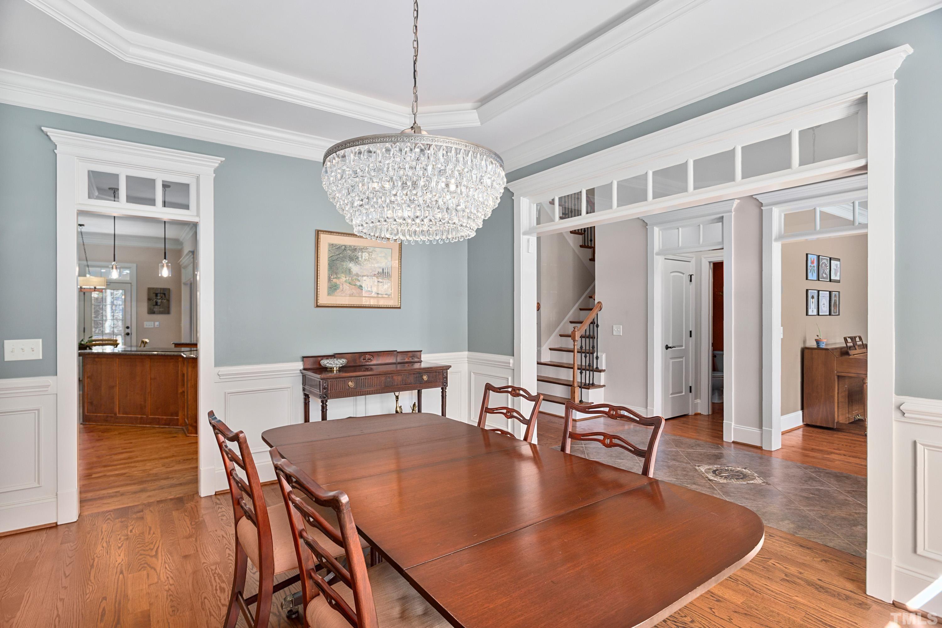4328 Summer Brook Drive Apex, NC 27539 - Photo 14 of 76 a dining room with wooden floor a chandelier a wooden table and chairs
