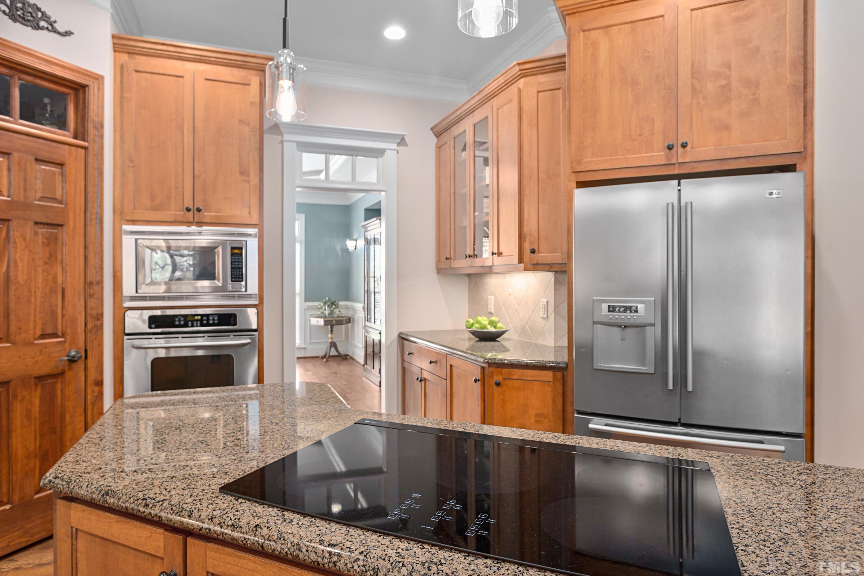 4328 Summer Brook Drive Apex, NC 27539 - Photo 16 of 76 a kitchen with stainless steel appliances granite countertop a refrigerator a stove and a sink with wooden floor