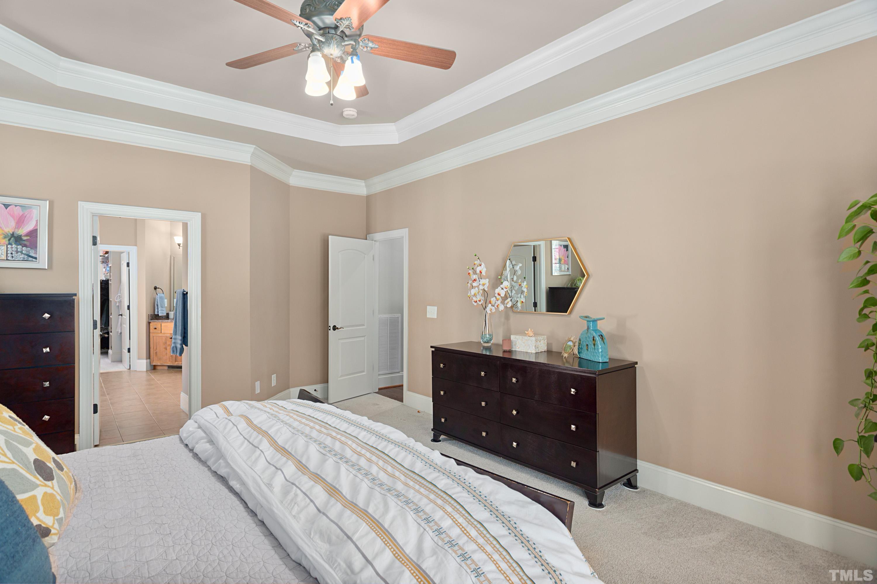 4328 Summer Brook Drive Apex, NC 27539 - Photo 31 of 76 a bedroom with a bed and a chandelier