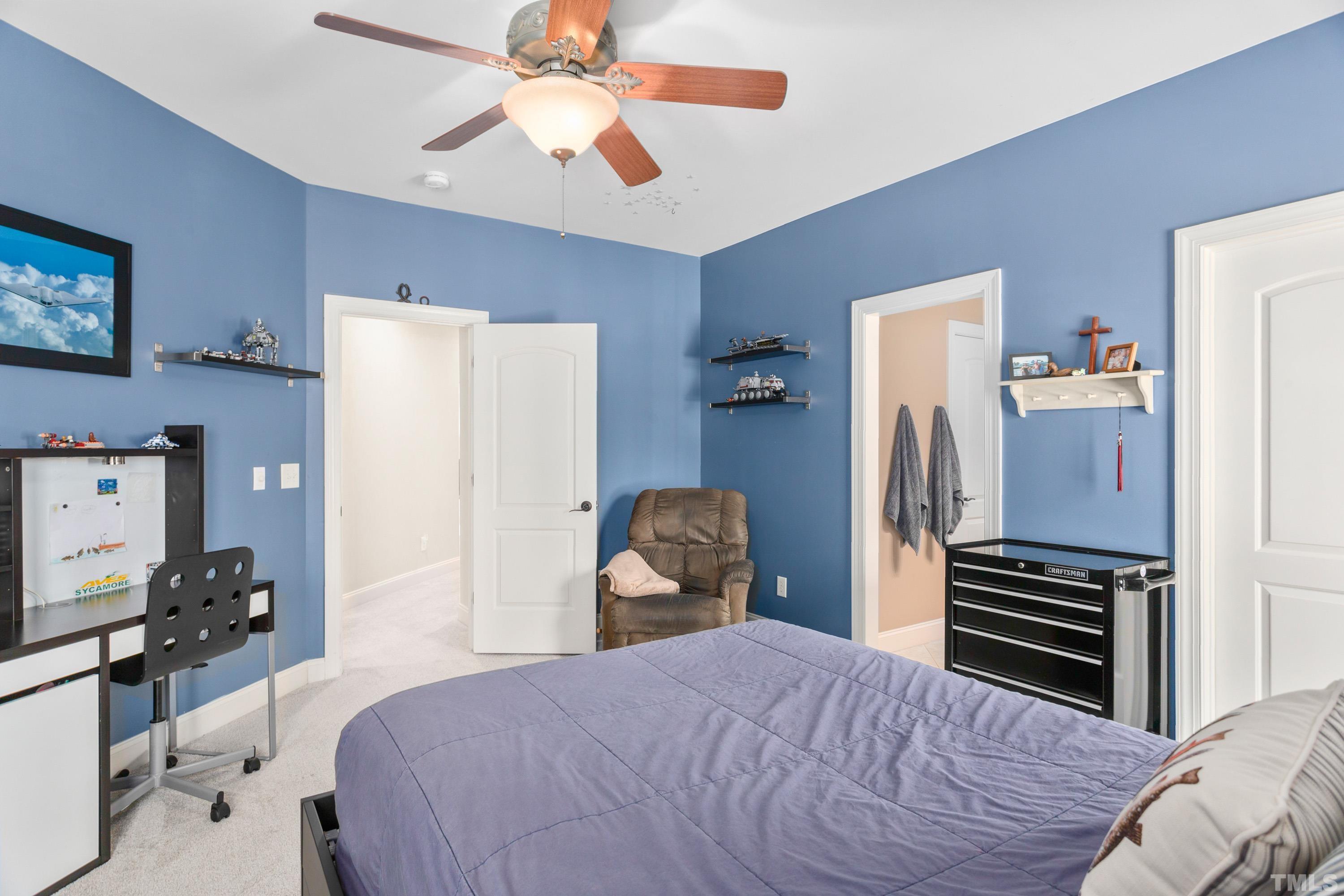 4328 Summer Brook Drive Apex, NC 27539 - Photo 48 of 76 a bedroom with a bed and a chandelier