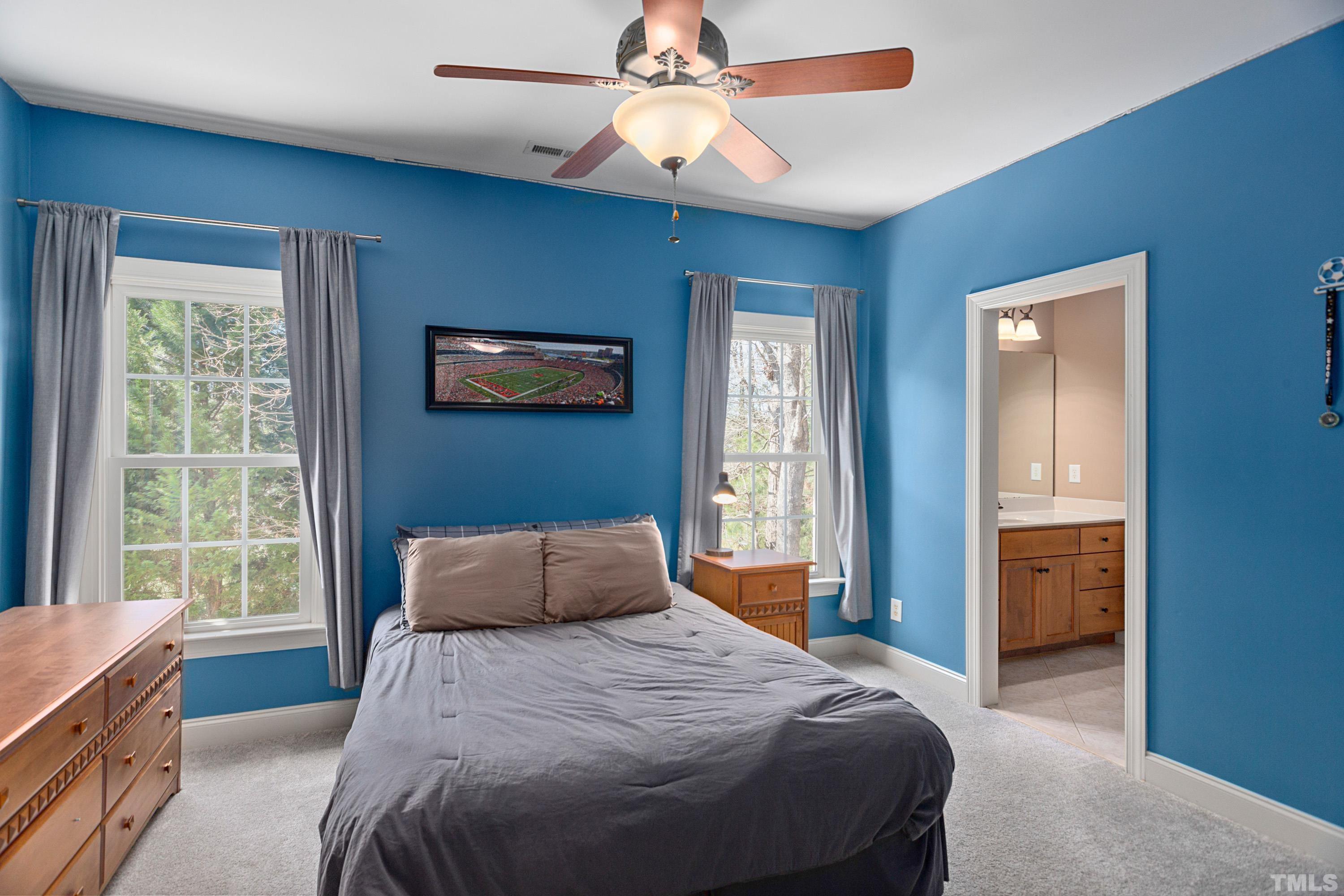 4328 Summer Brook Drive Apex, NC 27539 - Photo 53 of 76 a bedroom with a bed and a chandelier