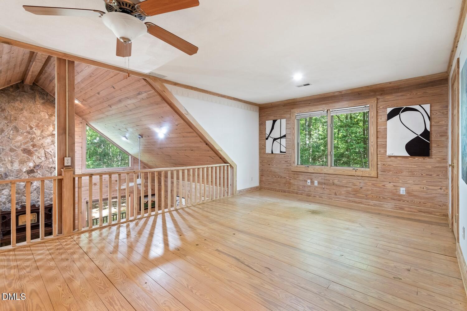 7391 Howerton Road Elon, NC 27244 - Photo 34 of 53 Wood-finish flooring with wood paneling, a ceiling fan, and large windows