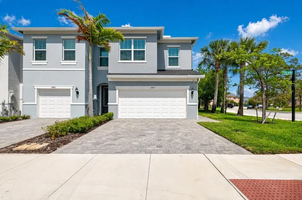 a front view of a house with a yard and a garage