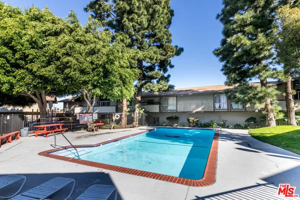 a view of a backyard with a fountain plants and large tree