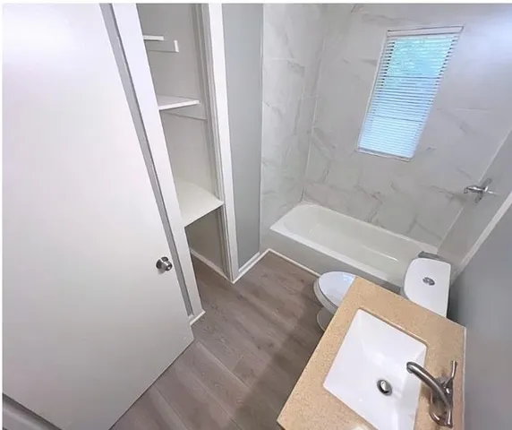 a bathroom with a granite countertop toilet a sink and a bathtub
