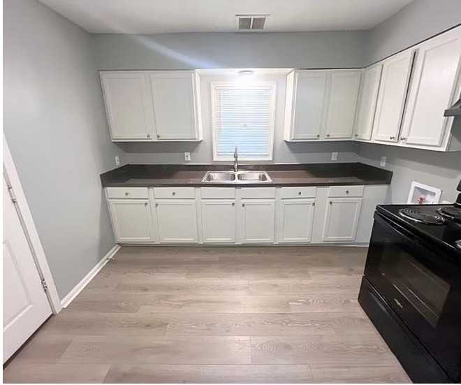 720 Rosebanks Road Memphis, TN 38116 - Photo 3 of 19 Kitchen with black electric range, dark wood-style floors, dark countertops, and white cabinetry