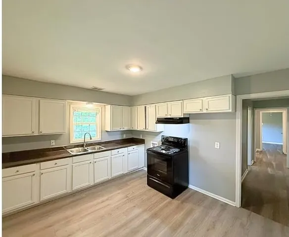 a kitchen with granite countertop a sink and steel appliances