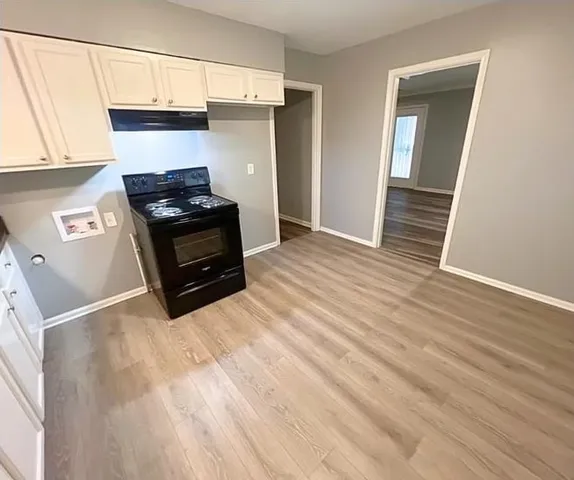 a kitchen with granite countertop a stove and a wooden floor