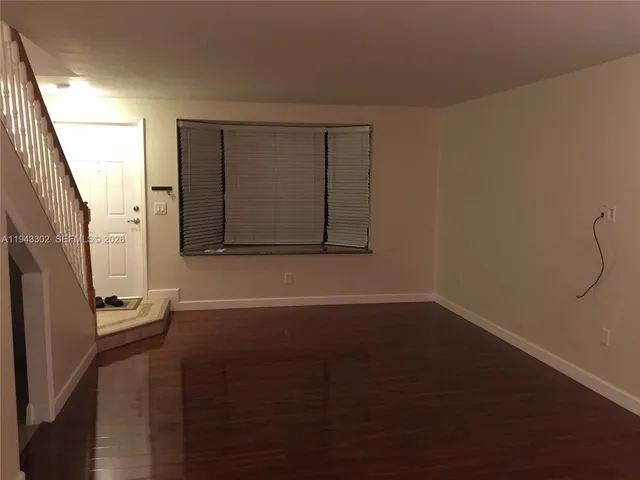 a view of a room with wooden floor and a window