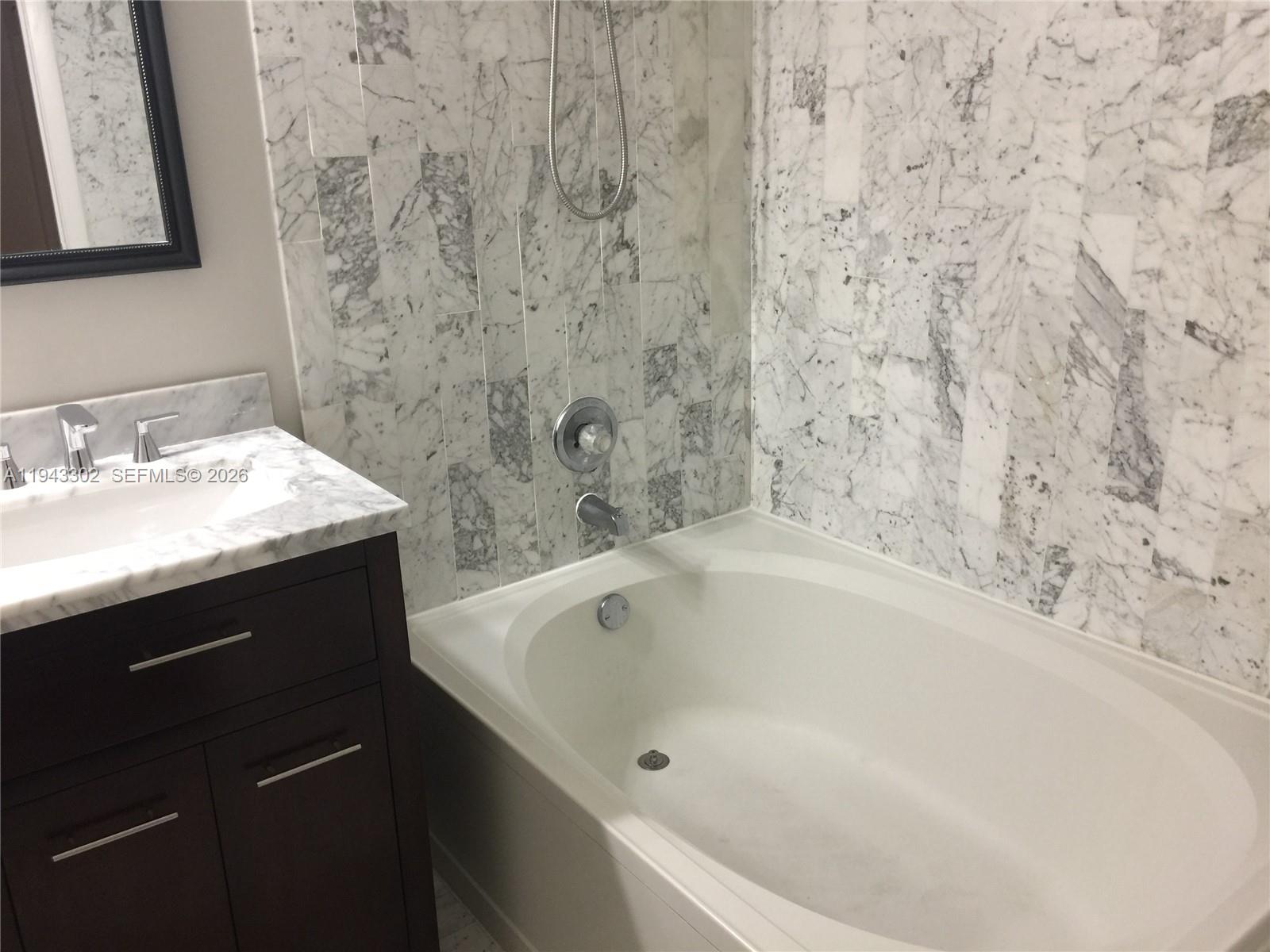 10033 Southwest 77th Court, Unit 10033 Miami, FL 33156 - Photo 7 of 10 a bathroom with a bathtub and sink