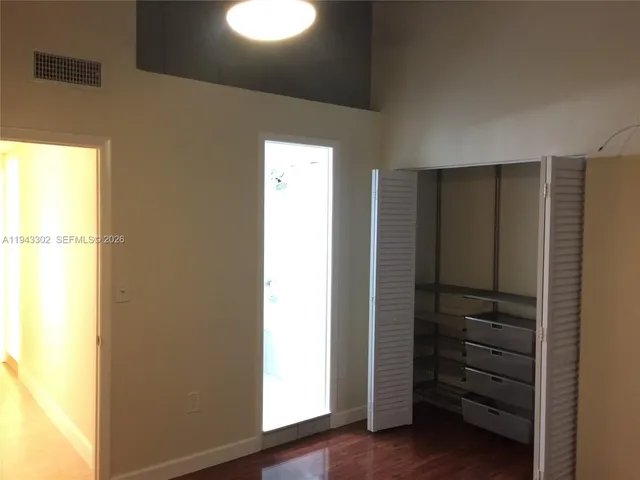 a view of walk in closet with empty racks