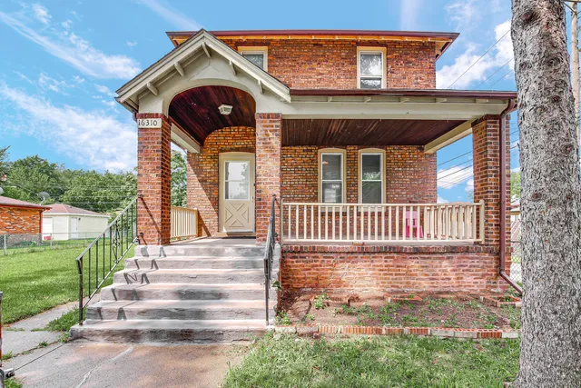 a view of a house with a small yard and wooden floor and fence