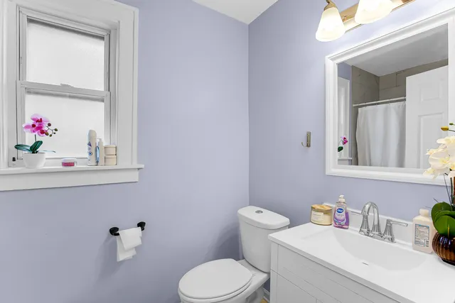 a bathroom with a toilet sink vanity and mirror