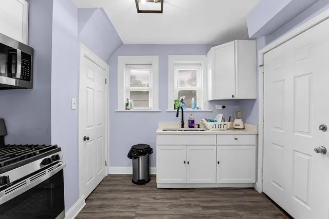 a kitchen with granite countertop white cabinets and stainless steel appliances