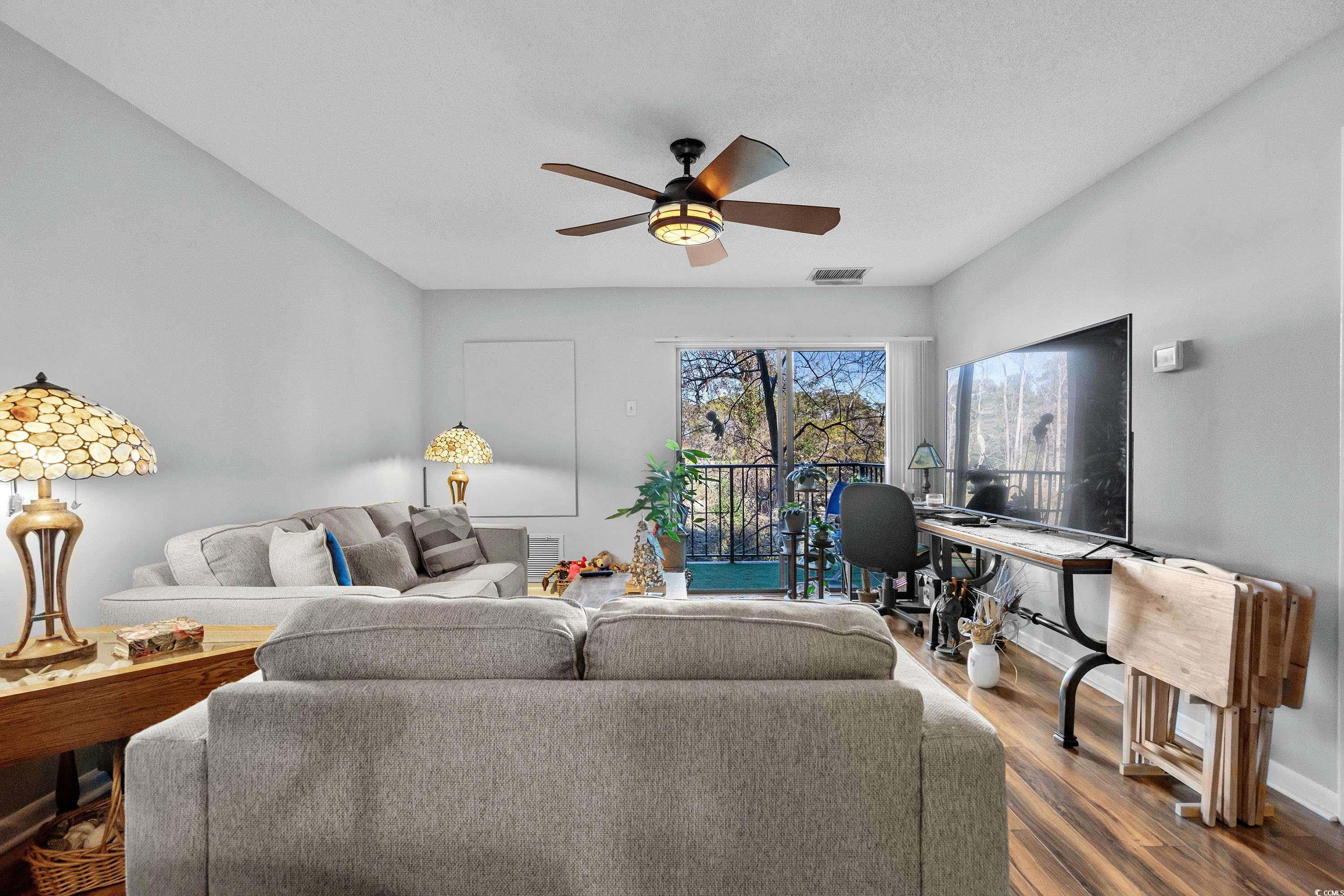 Living room featuring ceiling fan and wood-type fl