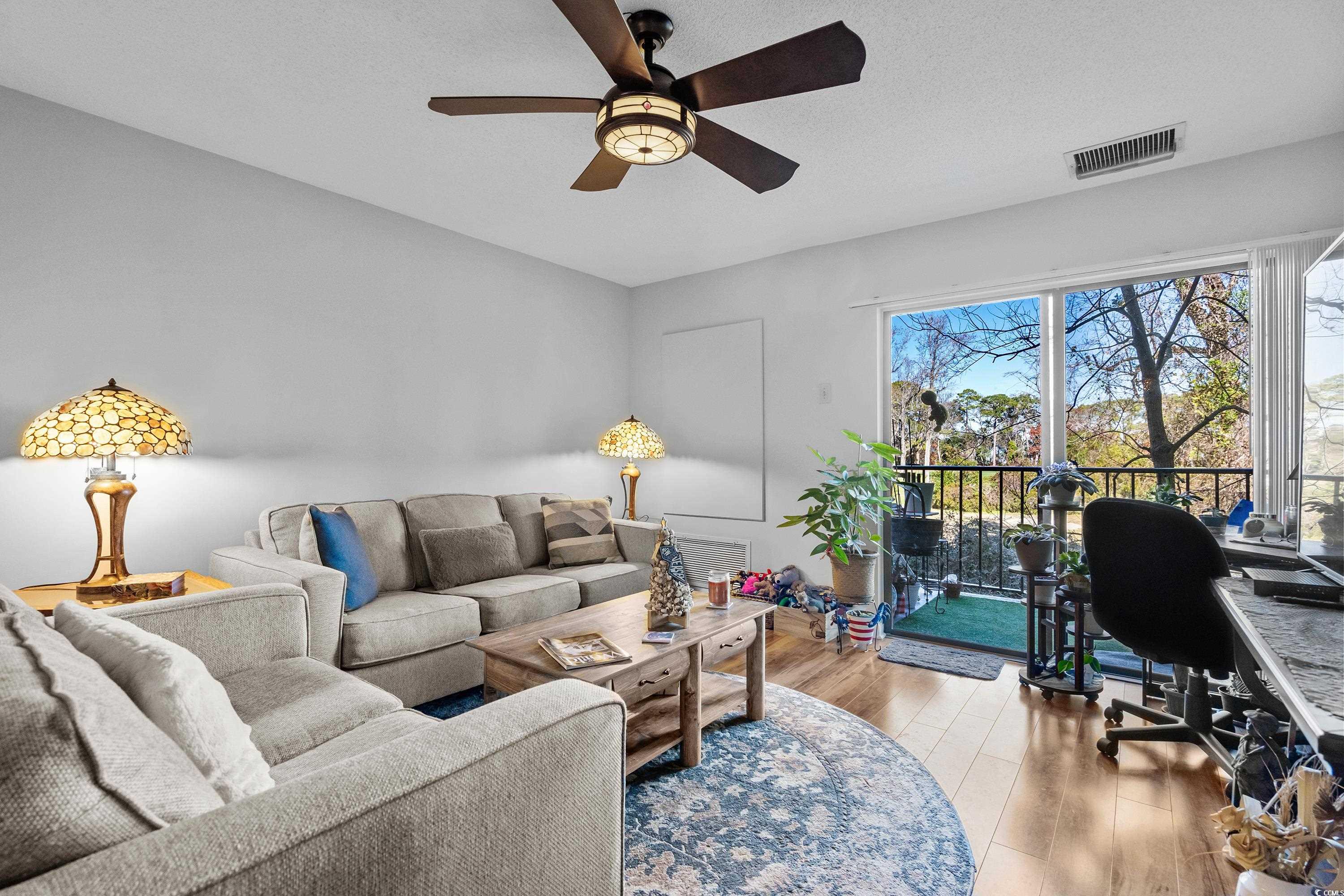 Living room featuring ceiling fan and light hardwo