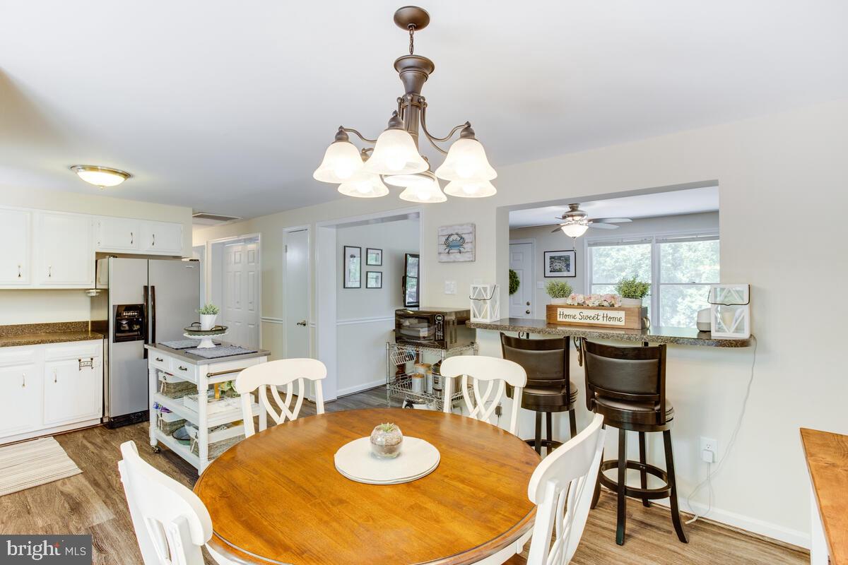1260 Coster Road Lusby, MD 20657 - Photo 12 of 46 a view of a dining room with furniture and a chandelier
