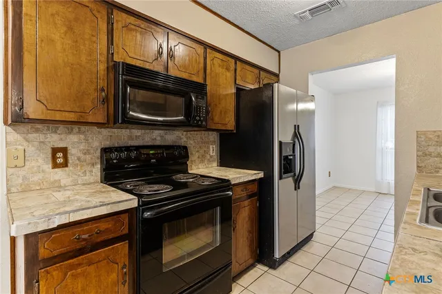 a kitchen with stainless steel appliances granite countertop a stove microwave and refrigerator