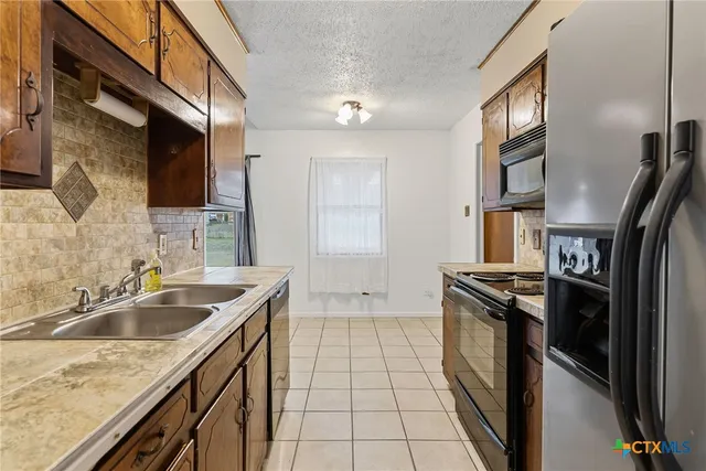 a kitchen that has a sink a stove and a oven