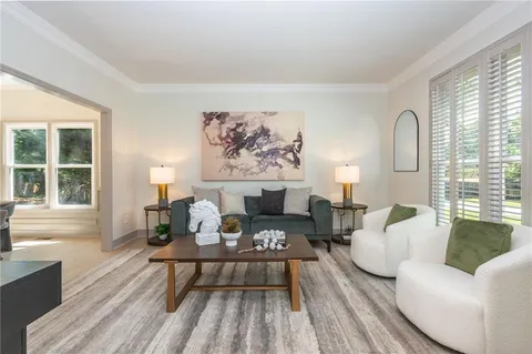a living room with furniture a fireplace and large window