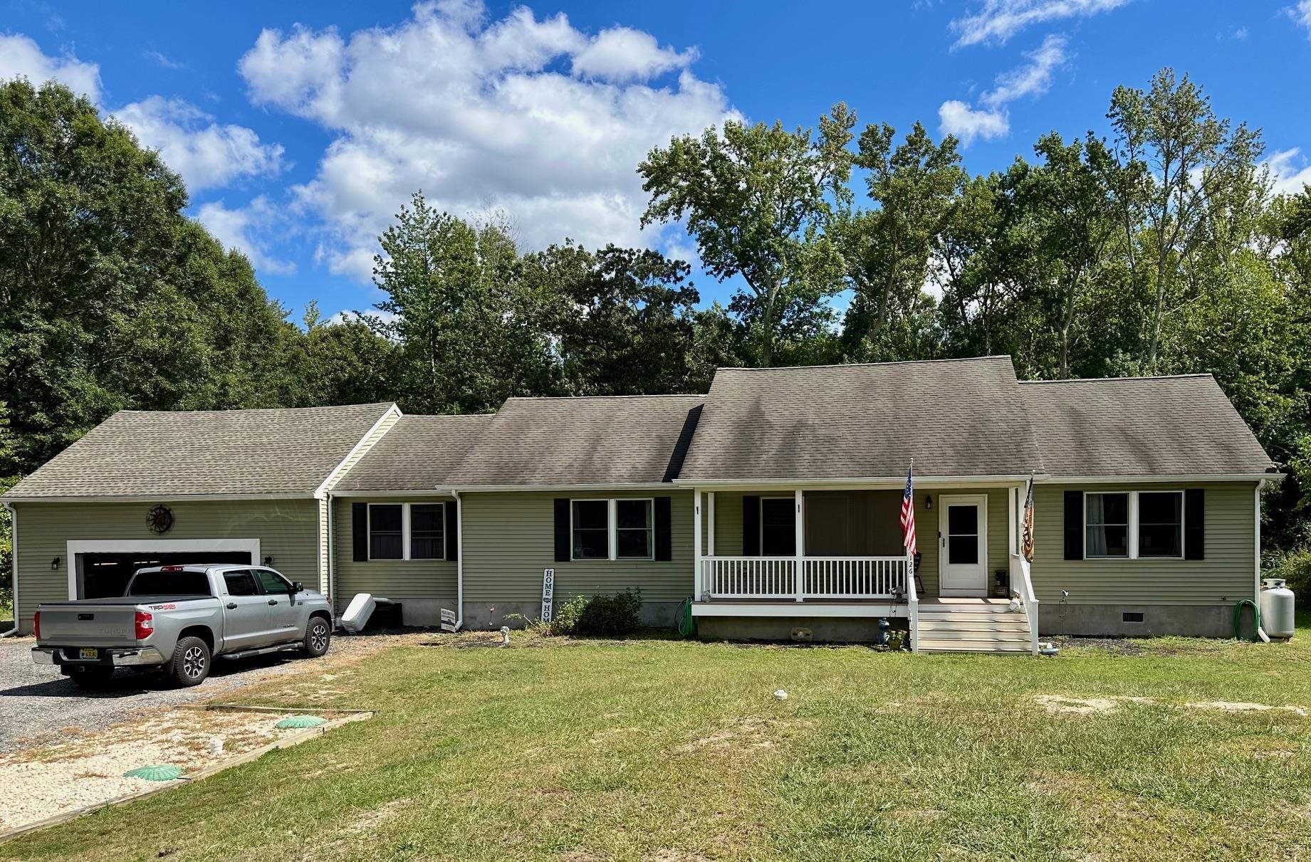 a view of a white house with a large pool lawn chairs and a yard