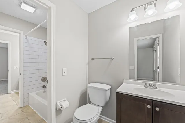 a bathroom with a sink a toilet and shower a mirror