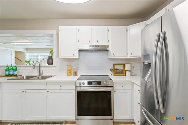 a kitchen with cabinets stainless steel appliances and a counter space