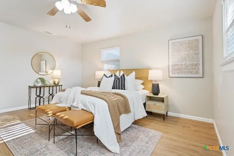 a bedroom with a bed a chandelier and a window