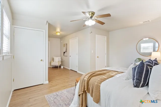 a bedroom with bed and wooden floor