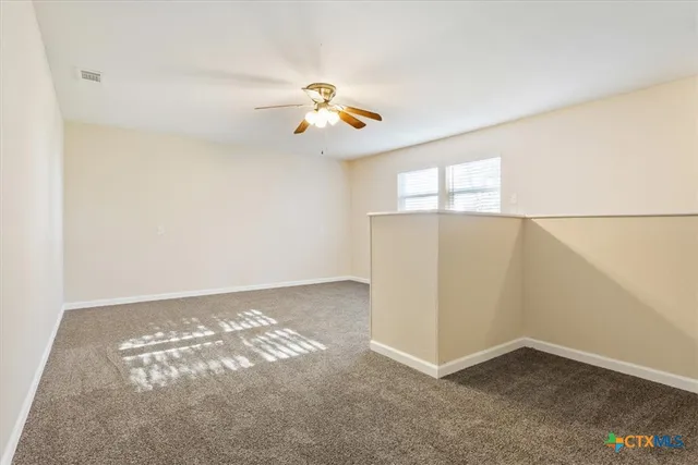 an empty room with windows and cabinet