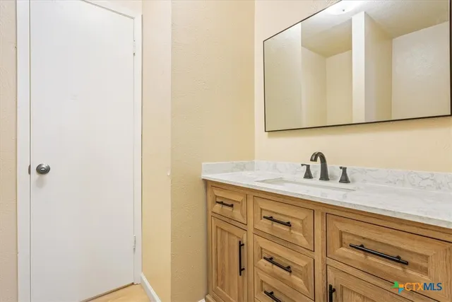 a bathroom with a granite countertop sink and a mirror