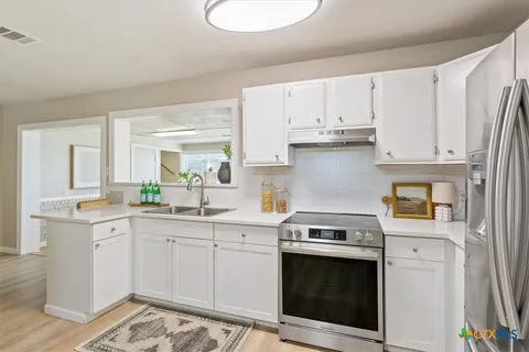 a kitchen with cabinets appliances and a sink