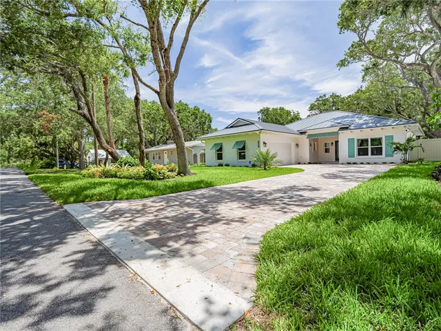 a front view of a house with a yard and trees