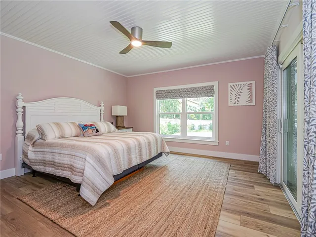 a bedroom with a large bed wooden floor and window