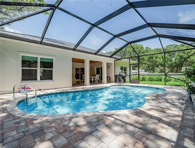 a view of a backyard with table and chairs under an umbrella