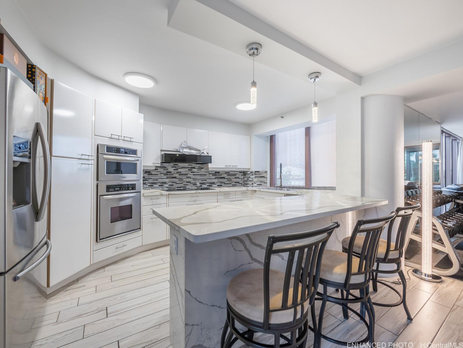 425 South Street, Unit 501 Honolulu, HI 96813 - Photo 5 of 25 a kitchen with stainless steel appliances kitchen island granite countertop a kitchen island and chairs in it