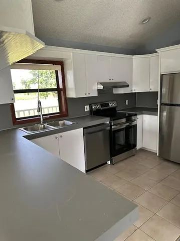a kitchen with stainless steel appliances a sink stove and cabinets