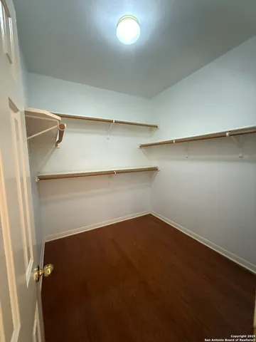 an empty room with a wooden floor and closet