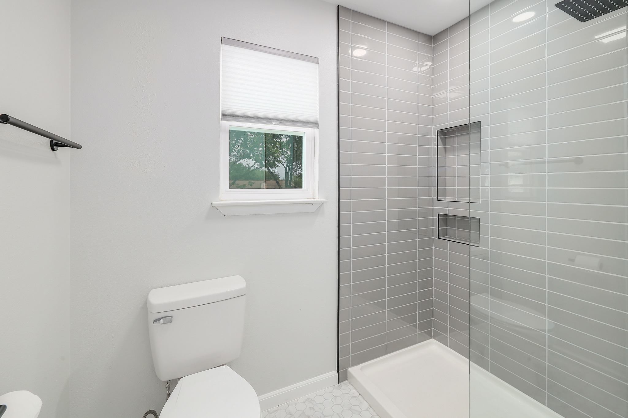 9614 Chukar Circle Austin, TX 78758 - Photo 14 of 26 Featuring a spa-inspired frameless glass walk-in shower with sleek grey subway tile backsplash.