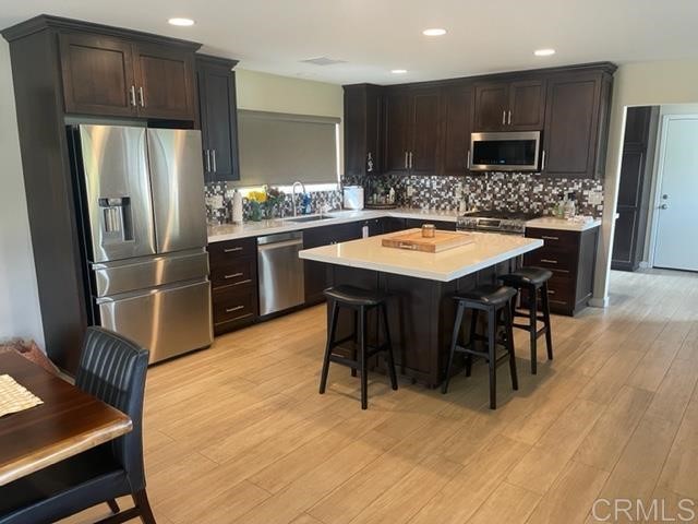 3129 Impink Place Jamul, CA 91935 - Photo 6 of 6 a kitchen with stainless steel appliances kitchen island granite countertop a table chairs and a refrigerator