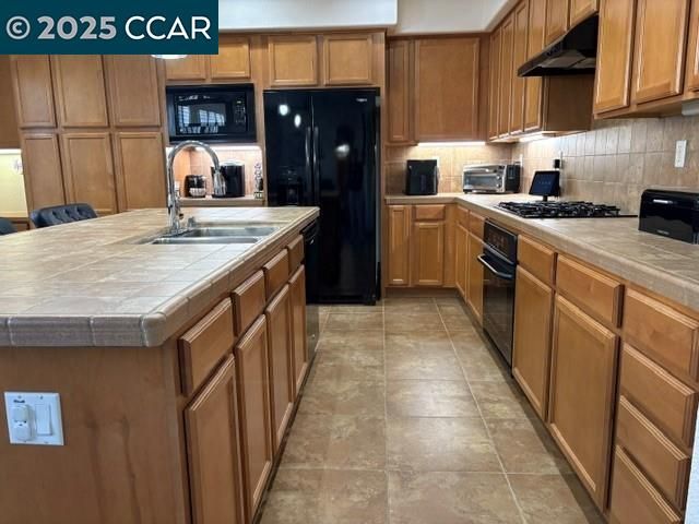 a kitchen with stainless steel appliances granite countertop a sink a counter top space cabinets and a view of living room