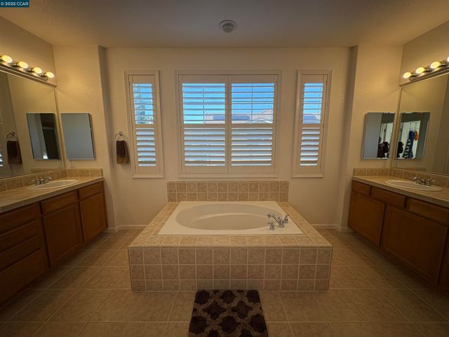 a bathroom with a tub sink and mirror