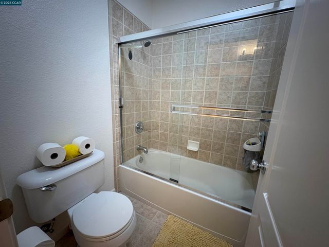 a white toilet sitting next to a bath tub