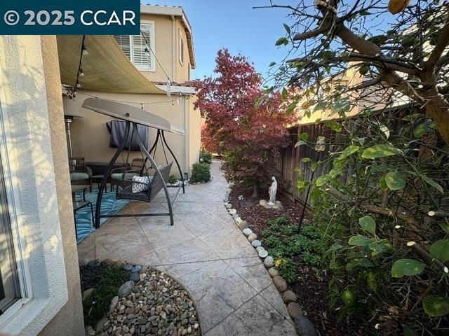 a view of a patio with couches table and chairs with wooden fence
